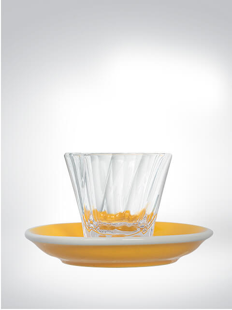 Verre transparent sur une soucoupe jaune